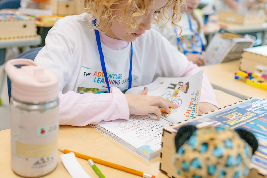 Child focused on reading the workbook